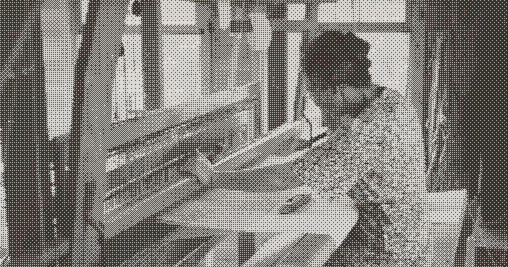 Image of a female weaver using a loom